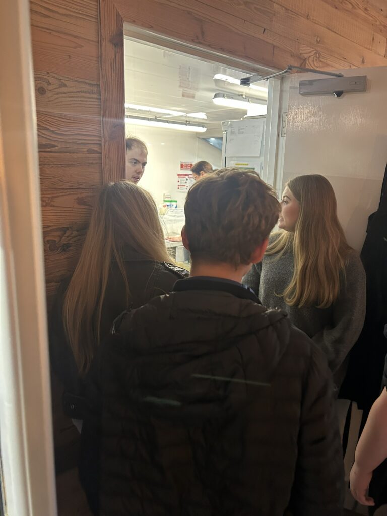 A group of teenagers standing by the kitchen's door at People First